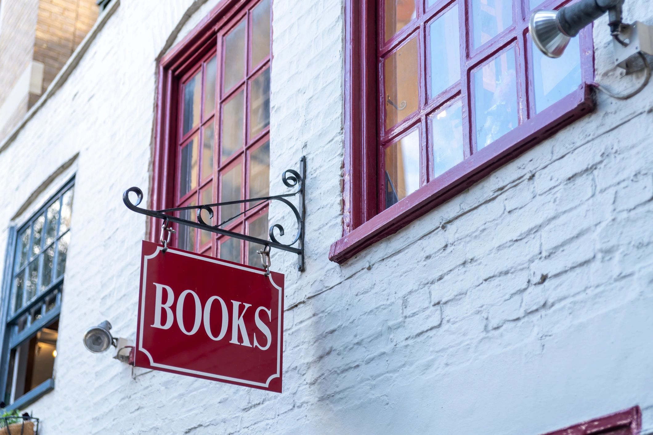 Outdoor vintage book market with rows of books under shady trees