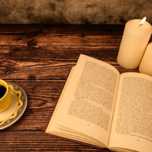 Cozy reading scene with coffee, candles and open book, copy space