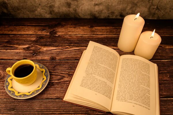 Cozy reading scene with coffee, candles and open book, copy space