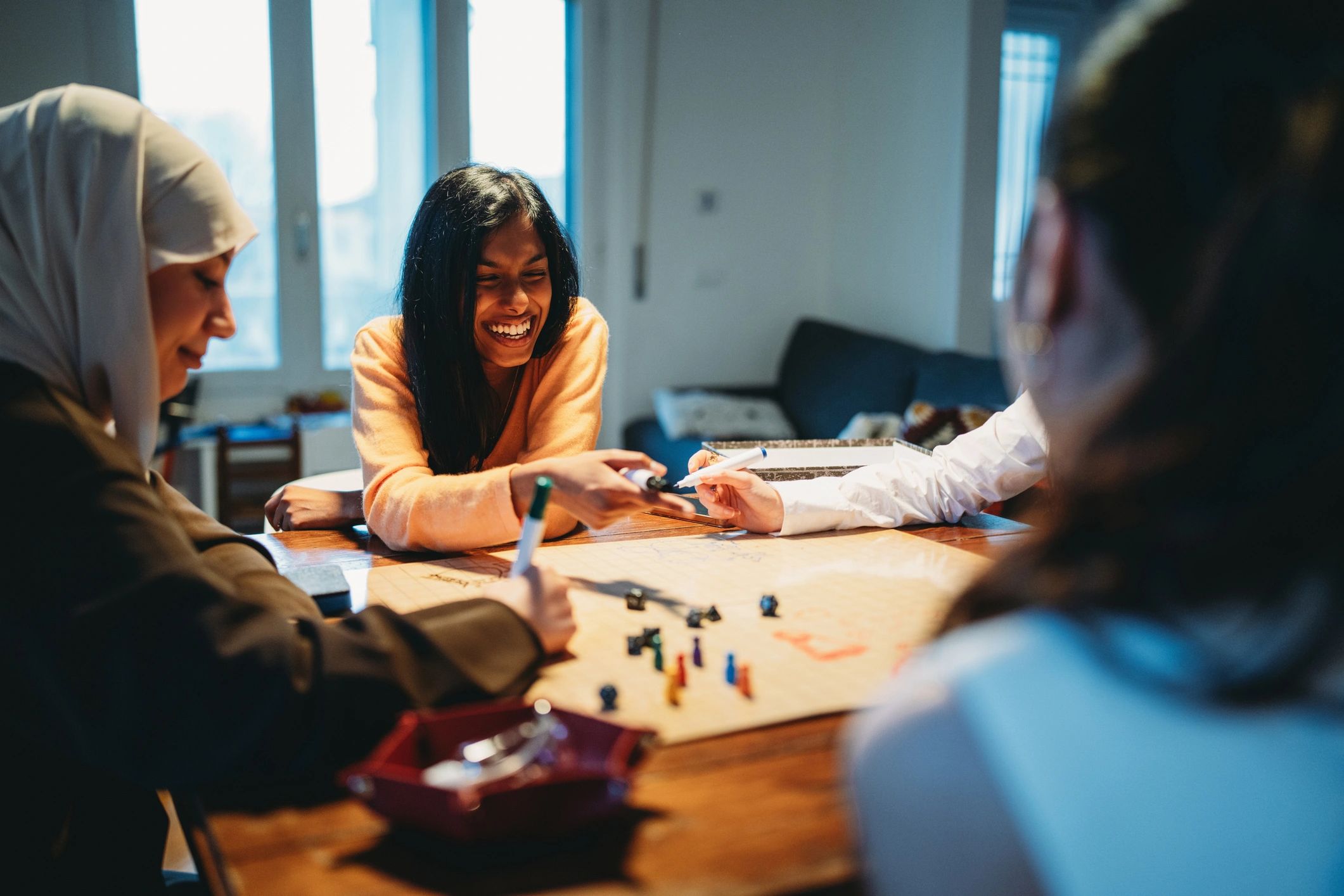 Friends gathered around a table enjoying a cozy game night together